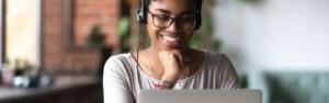 female student sitting at laptop wearing headphones