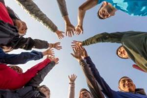 A group of students all putting their hands together