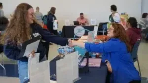 Student and school staff shaking hands at an event.